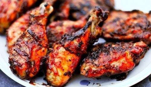 Plate of glazed grilled chicken drumsticks and thighs