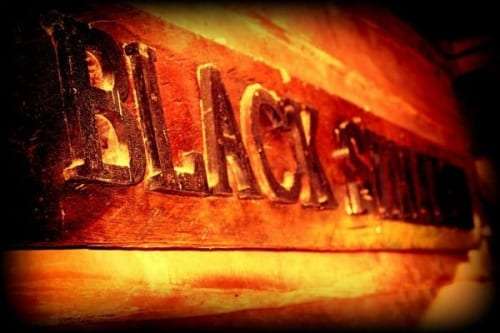 Carved wooden Black Stallion sign lit in warm light