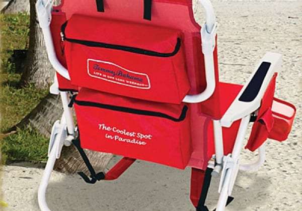 Red folding beach chair with a back pocket on sand